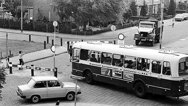 Zwartwit beeld van een stadsbus die over een casseienweg in Breda rijdt.