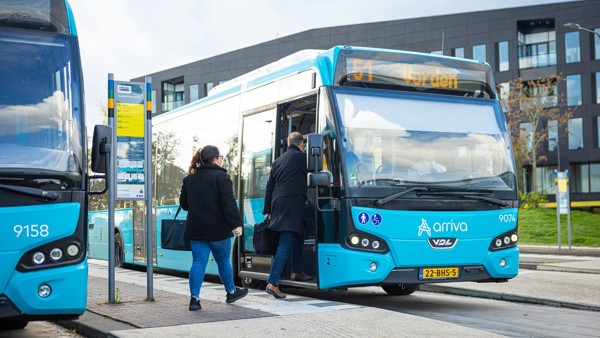 Blauwe bussen van Arriva, eentje met daarop '51 Vorden' staan bij de bushalte