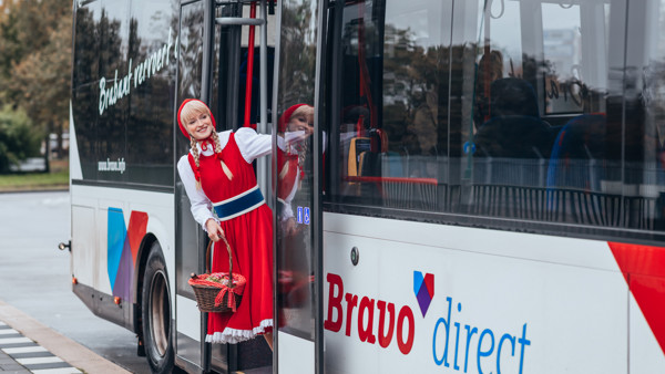 Roodkapje leunt uit deuropening rood-witte Arriva-bus. Roodkapje leunt uit deuropening rood-witte Arriva-bus.